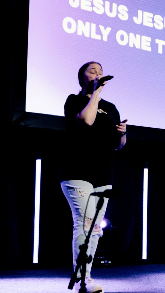 A girl leading worship on stage